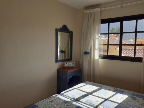 a bedroom with a bed and a mirror and a window at SUNSET HOUSE EL Cieno 10A in Valle Gran Rey