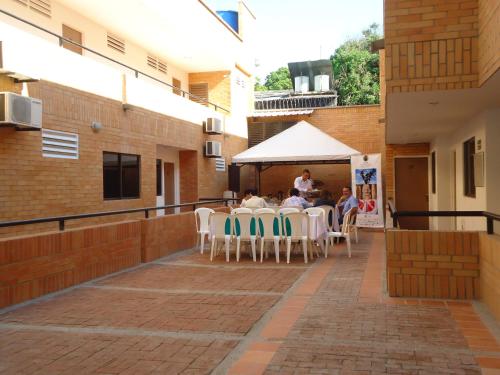 a group of people sitting at a table on a patio at Apartahotel Los Cerezos in Neiva