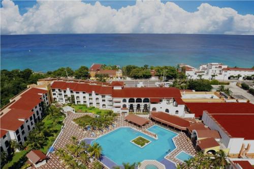 Cozumel Hotel & Resort TM by Wyndham All Inclusive في كوزوميل: اطلالة جوية على المنتجع والمحيط