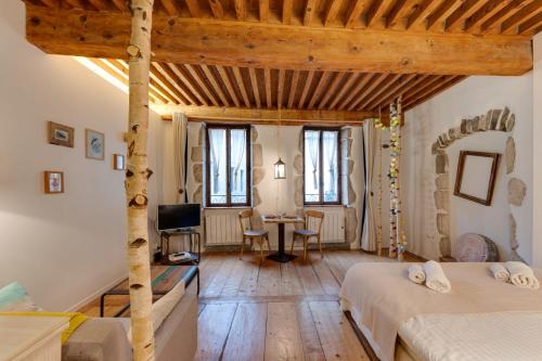 a bedroom with two beds and a desk with a television at La Cour Filaterie - Suite of 30 sq m in the Annecy breakfast included in Annecy