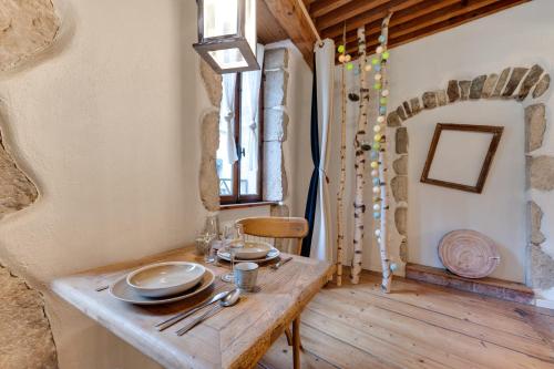 a dining room with a wooden table with plates on it at La Cour Filaterie - Suite of 30 sq m in the Annecy breakfast included in Annecy