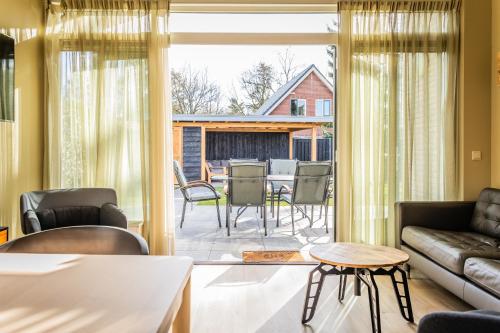 een woonkamer met een bank en een tafel bij Vakantiehuis in hét bomendorp van de Veluwe in Putten