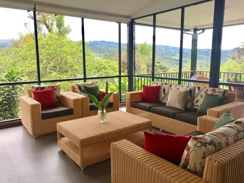 a living room with couches and tables and windows at POSADA DEL CAMINO REAL in Moniquirá