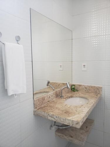 a bathroom with a marble sink and a mirror at Pousada Litorânea in São Luís