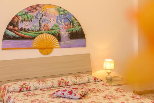 1 dormitorio con 1 cama y una pintura en la pared en Mini Hotel Rendez Vous, en Isquia