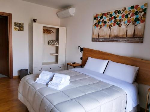 Un dormitorio con una cama blanca con toallas. en B&B Ca' Restom, en Reggio Emilia