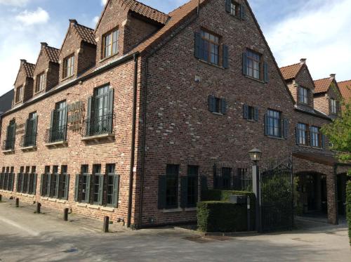 a large red brick building with black windows at Hotel ABBEY in Grimbergen