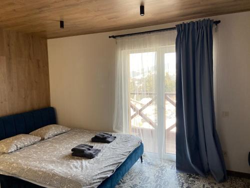 1 dormitorio con cama y ventana grande en DanRock en Yablunytsya