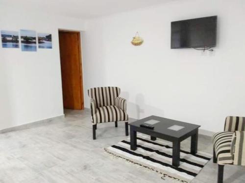 a living room with two chairs and a table and a television at H2o apart in Federación