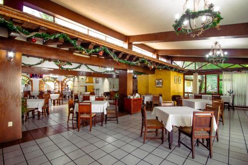 a dining room with white tables and chairs in a restaurant at Mision De Los Angeles in Oaxaca City