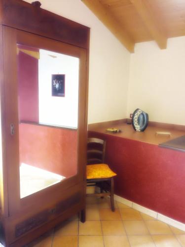 a room with a desk with a chair and a wooden door at APPARTAMENTO FERRARO TURINA in Motta Camastra