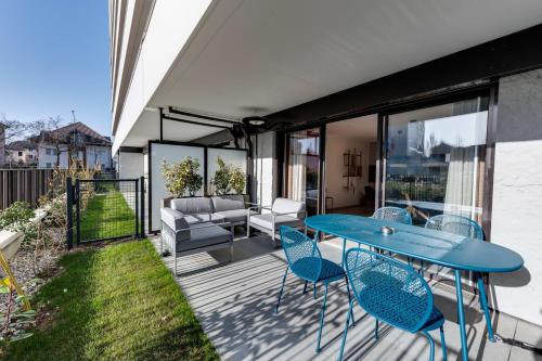 安錫的住宿－Le Reposoir - New 2 bedroom apartment with terrace & garage，庭院配有蓝色的桌椅