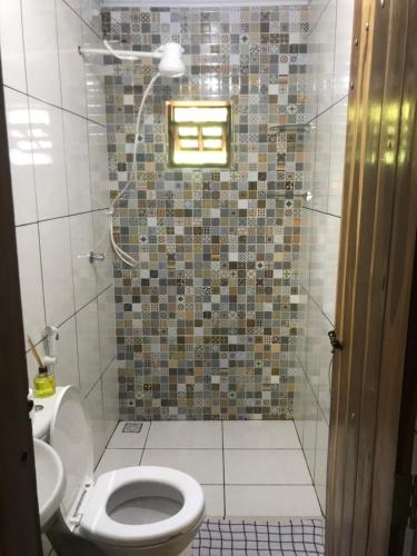 a bathroom with a shower with a toilet and a sink at Casa Encanto in Vale do Capao