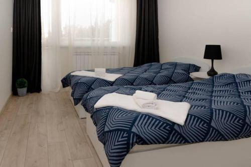 two beds in a bedroom with blue and white sheets at Super luxurious & spacious designer apartment. in Stara Zagora