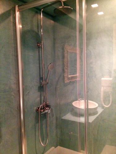 a shower with a glass door in a bathroom at Paradise Design Apartments in Batsi