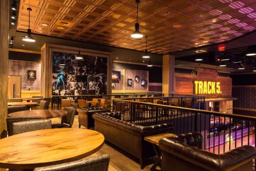 a restaurant with wooden tables and leather chairs at Hard Rock Hotel & Casino Tulsa in Tulsa