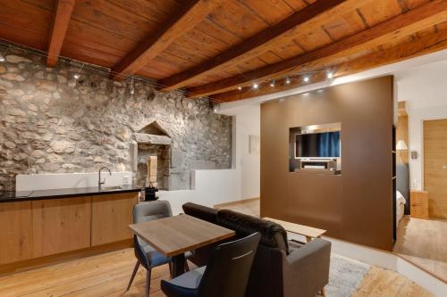 kuchnia i salon z kamienną ścianą w obiekcie La Cour Filaterie - Suite au cœur d'Annecy w Annecy