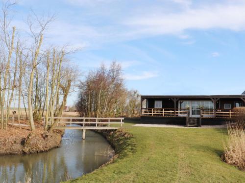 een gebouw met een brug over een rivier bij Fantastic brand new vacation home near the Wadden in Paesens