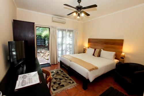 a bedroom with a bed and a ceiling fan at Roof of Africa Hotel in Windhoek