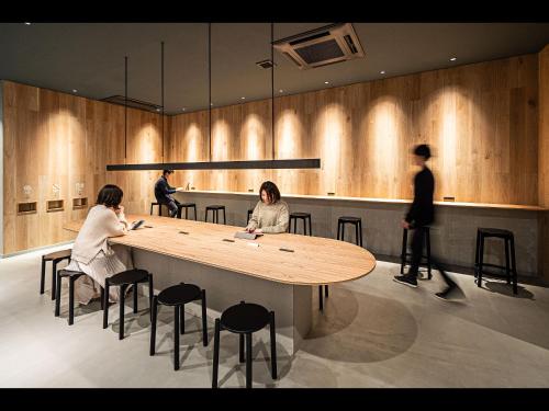 Due donne sedute a un tavolo in un ristorante di Capsule Plus Yokohama Sauna & Capsule a Yokohama