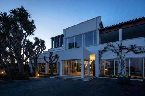 une maison blanche avec beaucoup de fenêtres dans l'établissement Senhora da Rosa, Tradition & Nature Hotel, à Ponta Delgada