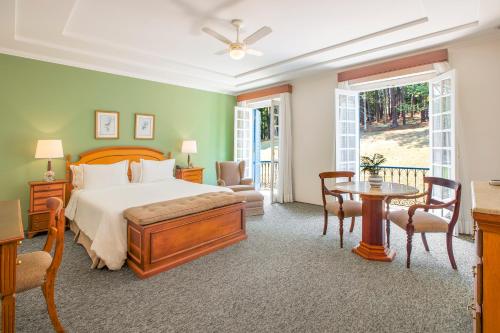 um quarto com uma cama, uma mesa e cadeiras em Hotel Fazenda Dona Carolina em Itatiba