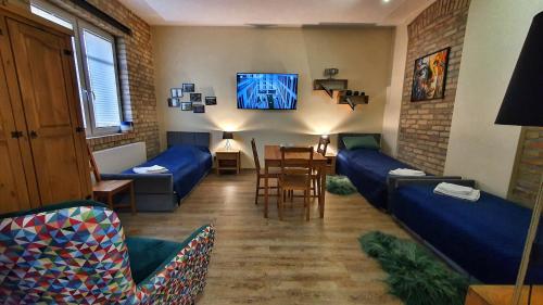 a living room with blue couches and a tv at Magiczne Mieszkanko in Piła