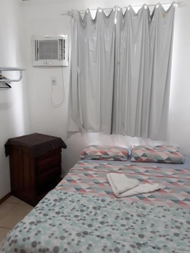 a bedroom with a bed and a window with a air conditioner at Apartamento Chapada Diamantina in Cuiabá