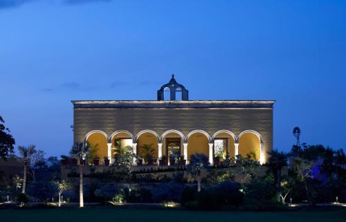 a building with a tower on top at night at Hacienda San Antonio Hool in Mérida