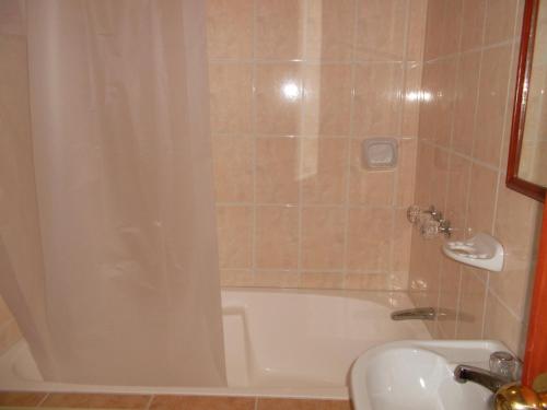 a bathroom with a white tub and a sink at Hotel KUTTY WASI VALLE SAGRADO in Urubamba