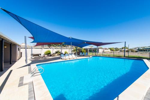 a blue swimming pool with a blue canopy over it at ibis Styles Geraldton in Geraldton