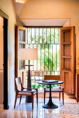 a table and chairs in a room with a window at Hacienda San Antonio Hool in Mérida