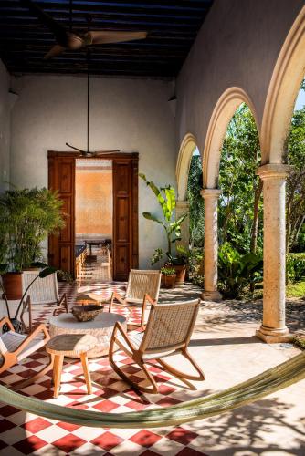 a patio with chairs and a table in a building at Hacienda San Antonio Hool in Mérida