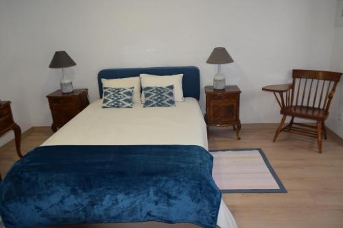 um quarto com uma cama grande com lençóis e almofadas azuis em Eiras do Dão em Penalva do Castelo