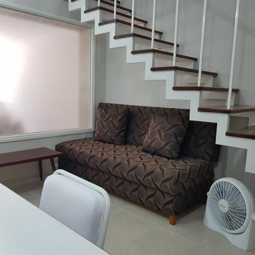 a living room with a couch and a staircase at Departamento Tres Arroyos HORNERO I in Tres Arroyos