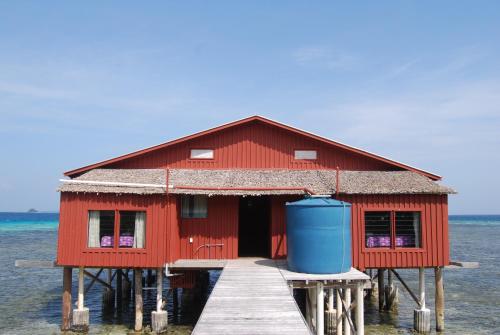 a red building on a dock in the water at Imagination Island in Gizo
