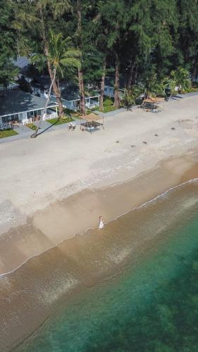 a person standing in the water on a beach at Thavorn Beach Village Resort & Spa Phuket in Kamala Beach