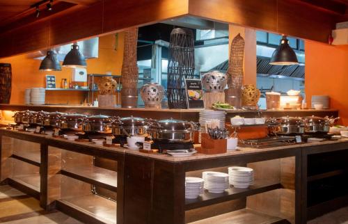 a kitchen with a counter with pots and pans at Thavorn Beach Village Resort & Spa Phuket in Kamala Beach