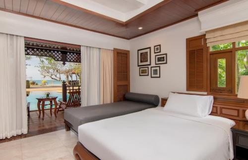 a bedroom with a bed and a view of a pool at Thavorn Beach Village Resort & Spa Phuket in Kamala Beach