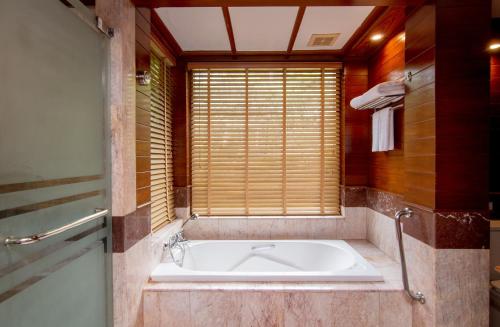 a bathroom with a tub and a sink at Thavorn Beach Village Resort & Spa Phuket - SHA Extra Plus in Kamala Beach