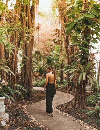 a woman walking down a path in a forest at Thavorn Beach Village Resort & Spa Phuket in Kamala Beach