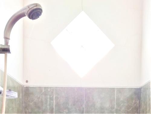 La salle de bains est pourvue d'un pommeau de douche et d'un lavabo. dans l'établissement Villa Orange Lembang Pengkolan, à Lembang