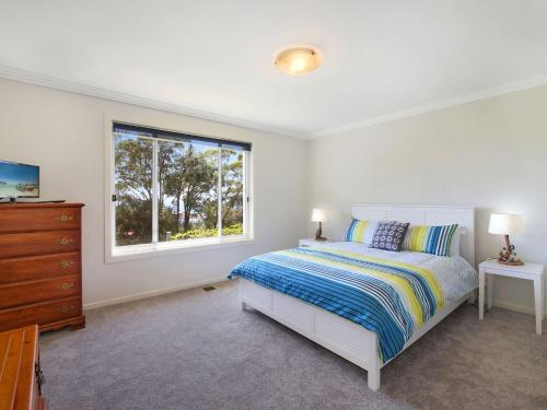 a bedroom with a bed and a window and a dresser at Enjoy Spectacular Oceanviews with BBQ & Airy Space in Terrigal