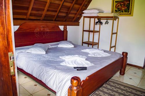 a bedroom with a bed with a blue and white blanket at Pousada Vale Verde in Monte Verde