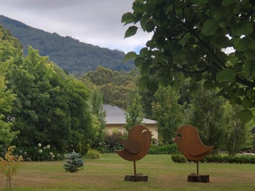 two metal bird sculptures in a field with a house at Wotama, Macedon B and B, Honour Ave, Mount Macedon in Mount Macedon