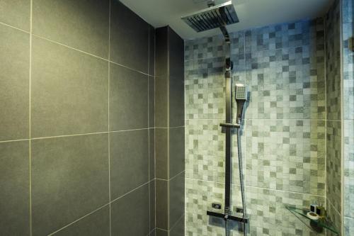 uma casa de banho com um chuveiro e paredes em azulejo em Art De Sea Hua Hin em Hua Hin