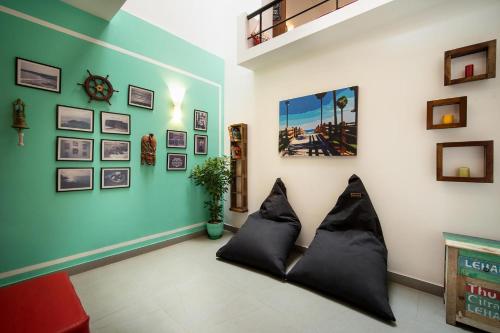 a living room with black pillows on a wall at StayVista at Saanu Ki Villa with free Breakfast in Candolim