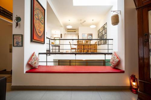 a living room with a red couch and a staircase at StayVista at Saanu Ki Villa with free Breakfast in Candolim