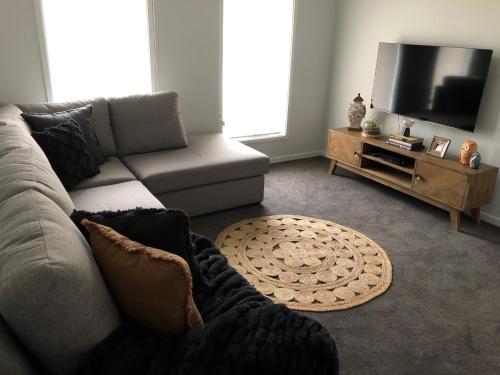 a living room with a couch and a flat screen tv at 63 Grigg in Koondrook