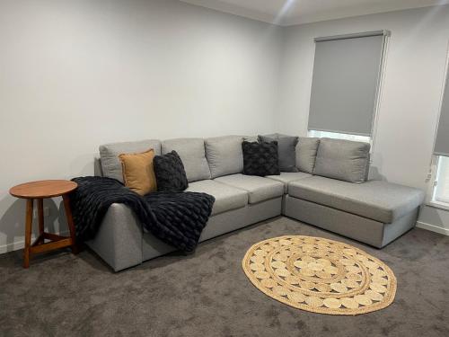 a living room with a gray couch and a table at 63 Grigg in Koondrook